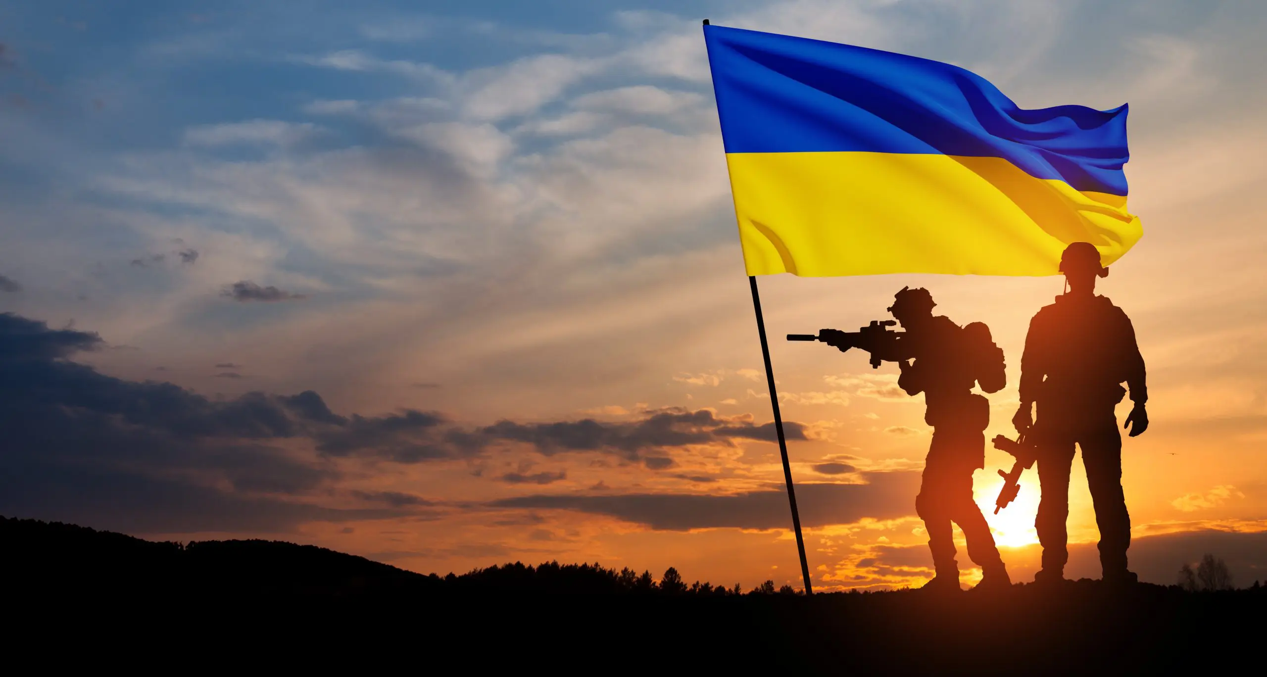 Flag of Ukraine with silhouette of soldiers against the sunrise or sunset. Concept armed forces of Ukraine.