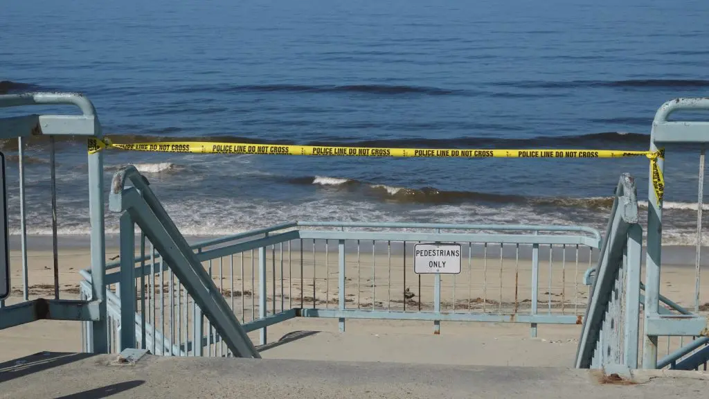 Yellow police tape blocks access to a beach closed due to Covid 19 pandemic.