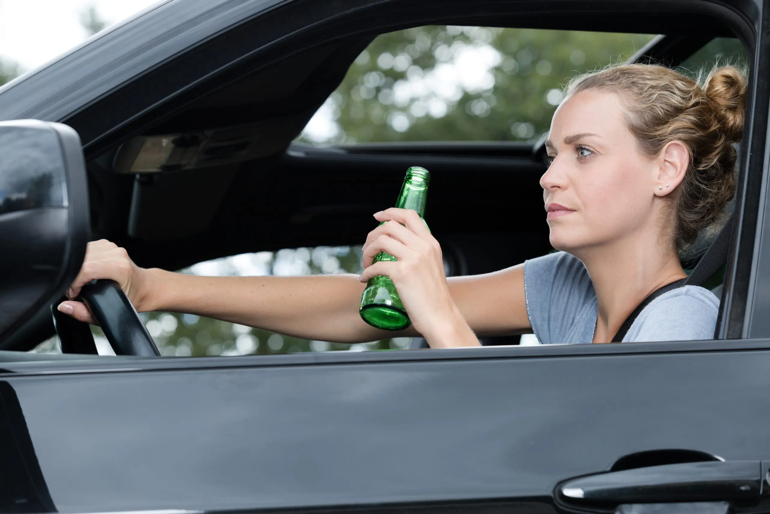 woman drinking beer while driving car